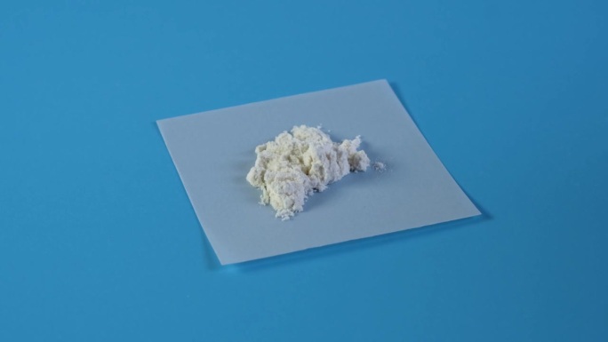 瓜尔胶粉或瓜尔兰在蓝色的背景。食品添加剂E412。瓜尔胶常用于乳制品。质地改善和改善乳脂