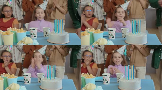 面目全非的孩子吹灭生日蛋糕上的蜡烛，客人鼓掌