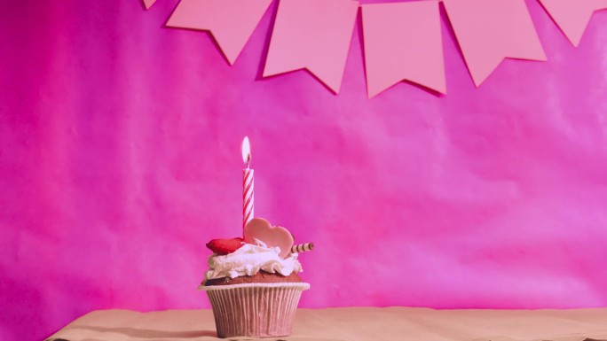 祝贺一个女孩的生日。粉红色背景上有蜡烛的蛋糕。周年纪念日。视频明信片在柔和的颜色。