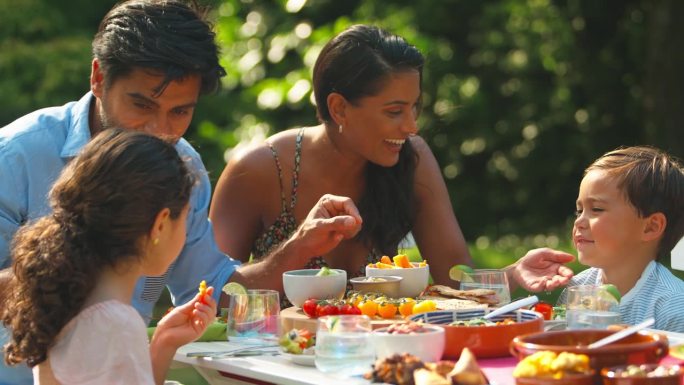 一家人在家里的夏日花园一起吃户外大餐