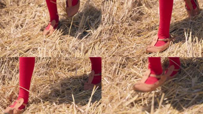 穿着民族传统皮鞋的保加利亚女孩走在收割后的麦田里