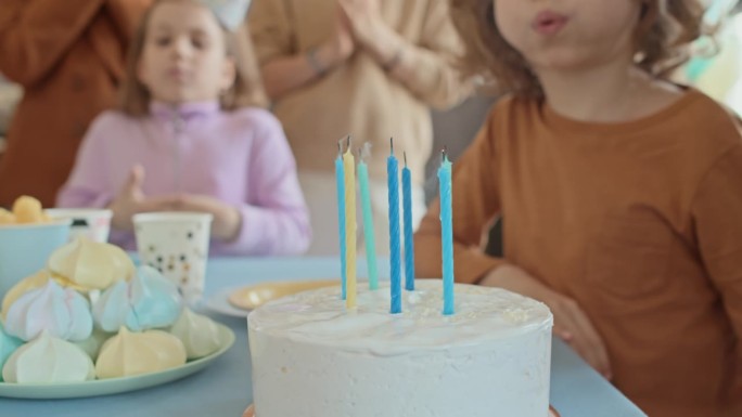 匿名小孩在派对上吹灭生日蛋糕上的蜡烛