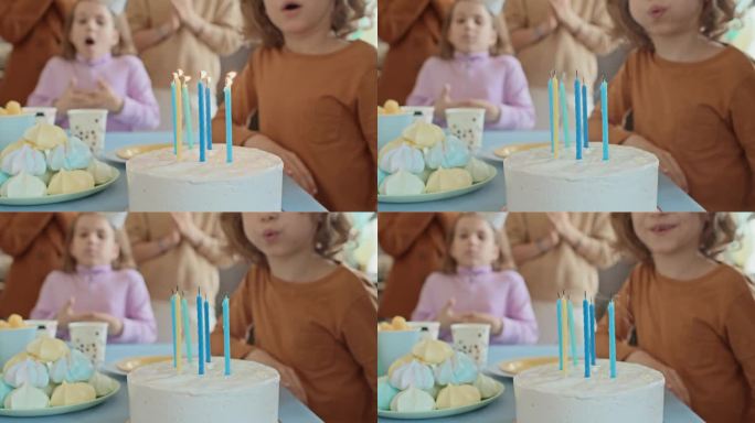 匿名小孩在派对上吹灭生日蛋糕上的蜡烛