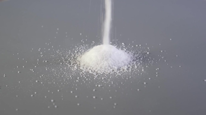 阿斯巴甜粉末倒在幻灯片上的灰色表面。代糖、人工甜味剂。化学式c14h18n2o5。食品添加剂E951