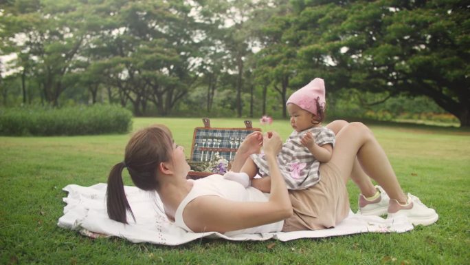 野餐时快乐的妈妈和她的孩子玩耍