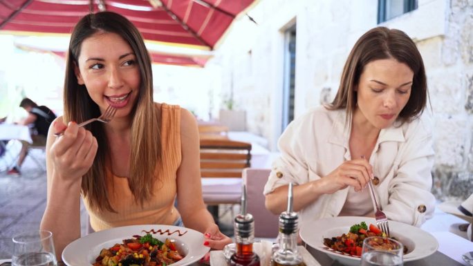 两名女游客在餐厅享用传统美食