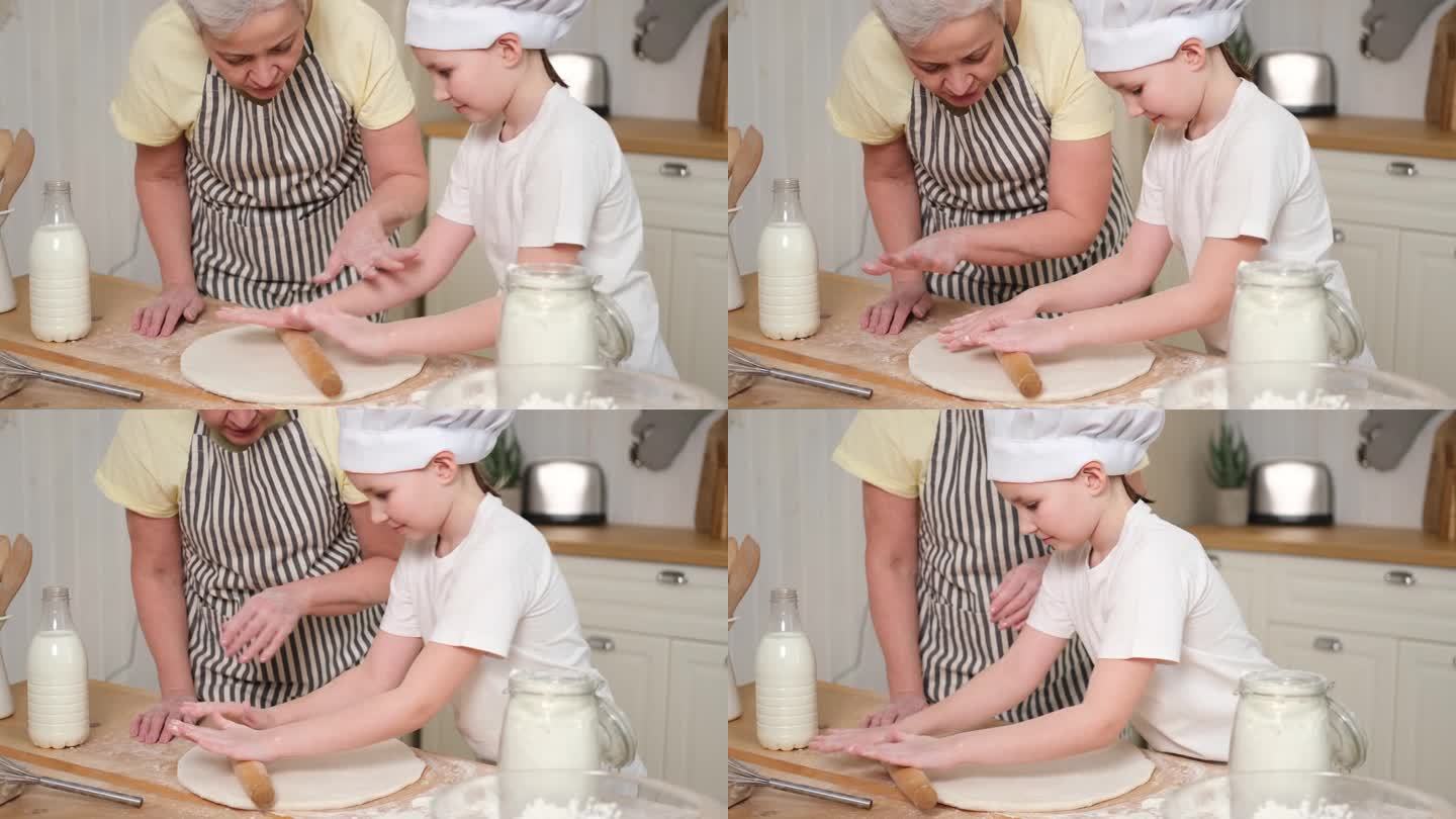 快乐的家庭在厨房。奶奶和孙女孩子一起在厨房做饭。奶奶教小女孩擀面烤饼干。家庭团队合作帮助家庭世代相传