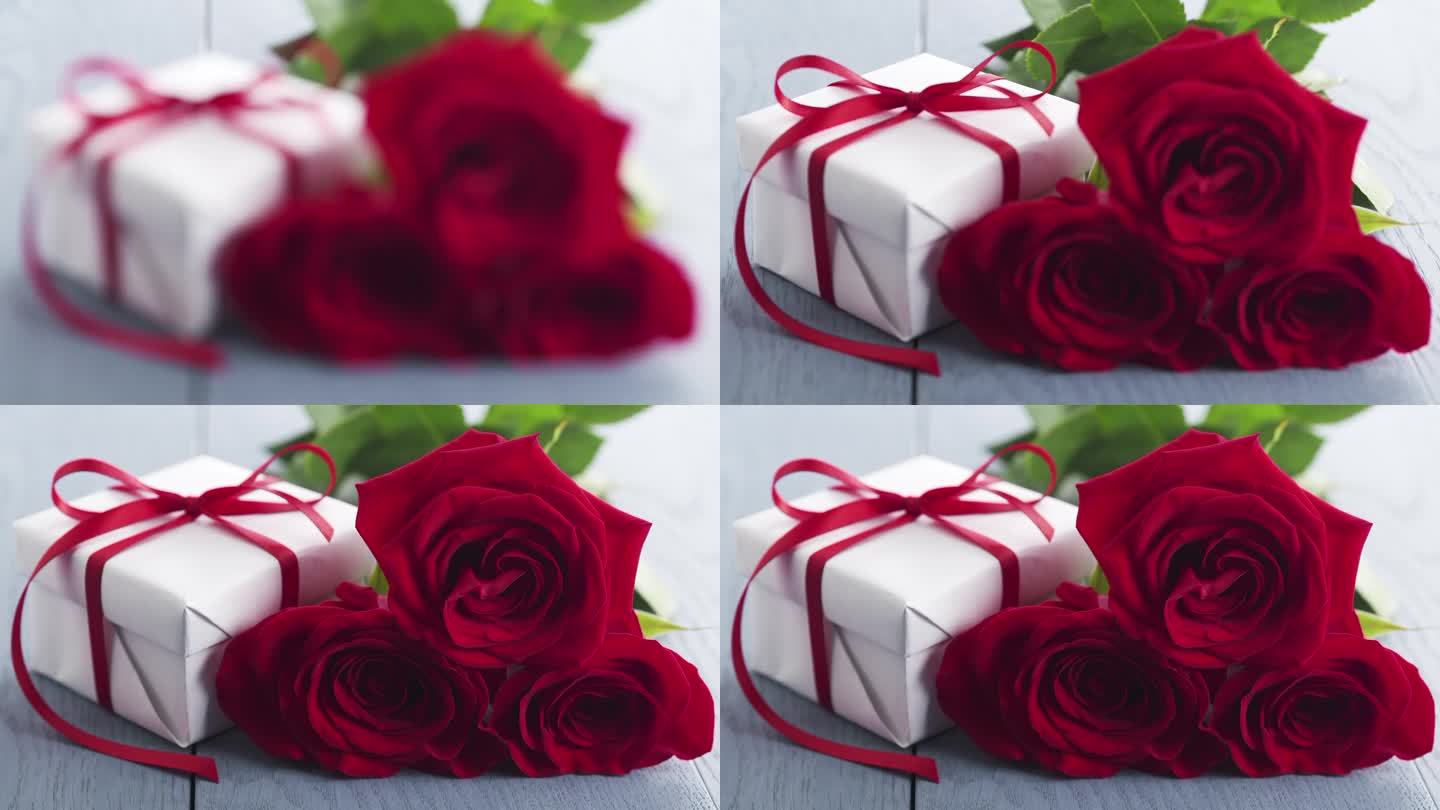 三朵红玫瑰和礼盒放在蓝色的木桌焦点拉