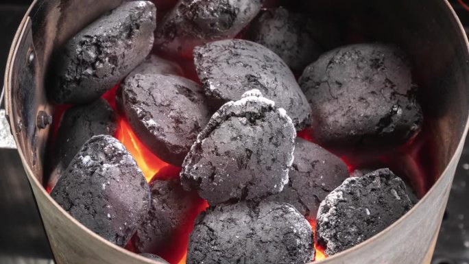 烟囱烤架起动器。烟熏木炭烧烤煤块的时间流逝。