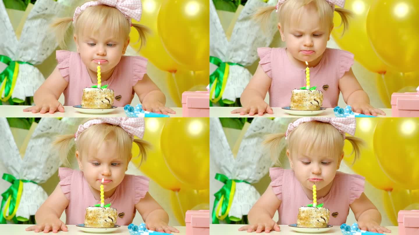 头上扎着两个马尾辫的可爱的生日女孩吹灭了生日蛋糕上的蜡烛。