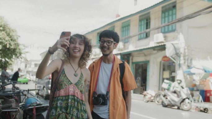 年轻的亚洲夫妇在曼谷旅行，在城市的各个地方拍照。