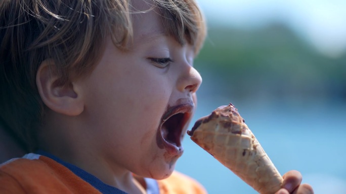孩子在吃甜筒冰淇淋。小孩肖像脸吃甜点