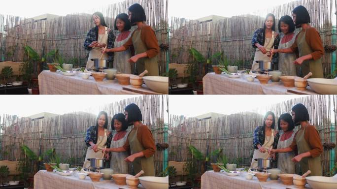 快乐的亚洲母亲和成年的女儿在后院准备传统的泰国菜——成年的女儿在汤里加酱油