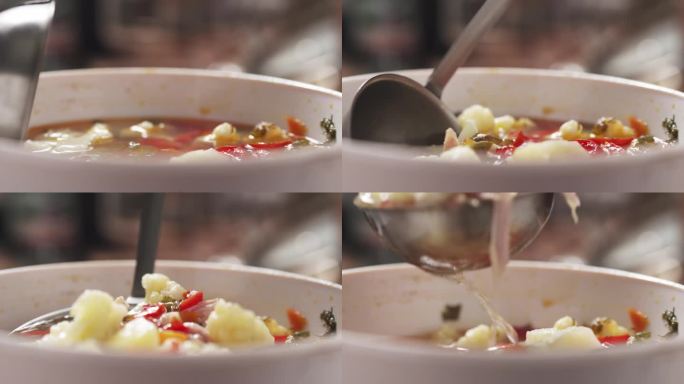 慢镜头特写:从木桌上的碗里舀菜花汤