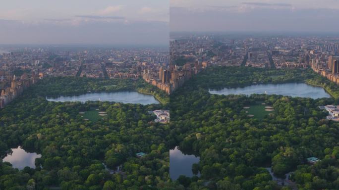 垂直屏幕:日落时分的纽约市景。直升机航拍画面。曼哈顿岛中央公园周围的现代摩天大楼。关注城市公园里的自