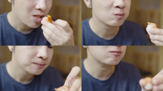 一名亚洲男子一边用手吃三文鱼扇贝明台寿司一边说话的特写镜头。吸吮手指。