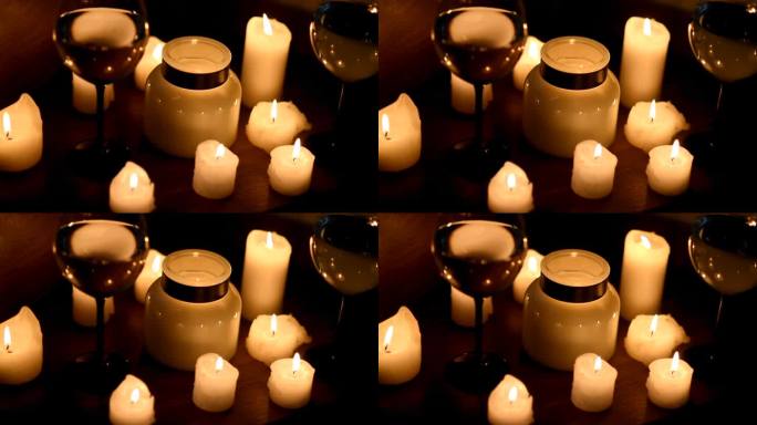 蜡烛和白葡萄酒在黑暗中。炉火在颤动，耀眼的光芒在闪烁。浪漫晚餐，温馨舒适。舒适的视频