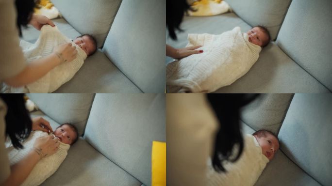 妈妈用毯子把婴儿包起来。刚出生的婴儿被母亲用毯子包裹在家里。