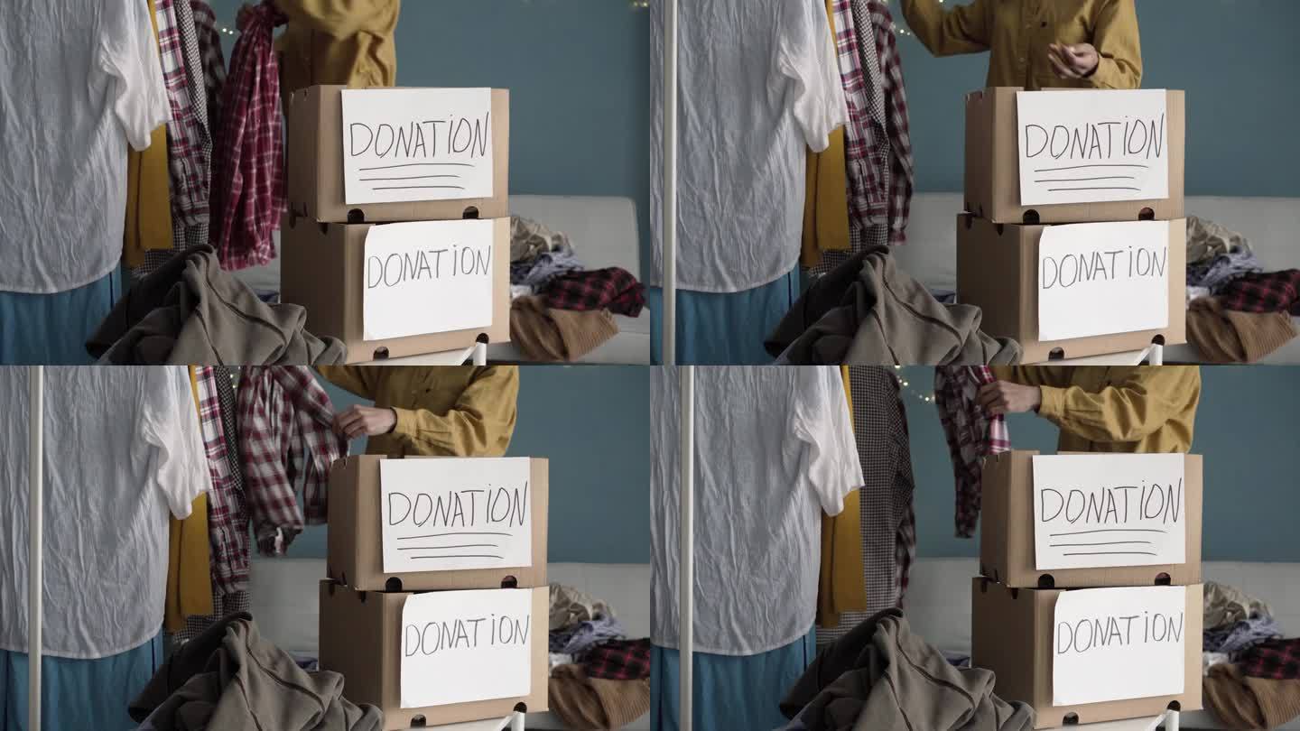 为穷人提供衣物的捐款箱。女性在家里拿着捐款箱的特写。一名妇女向收容所捐赠衣服。