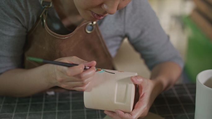 年轻女子在她的陶器作坊里制作手工陶瓷，小生意的概念