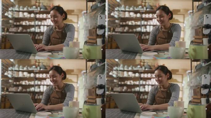 一名亚洲妇女在陶器工作室工作时使用笔记本电脑