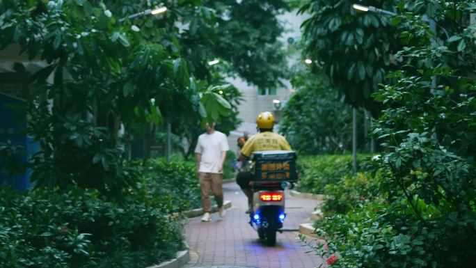 外卖员穿梭在小区内部道路