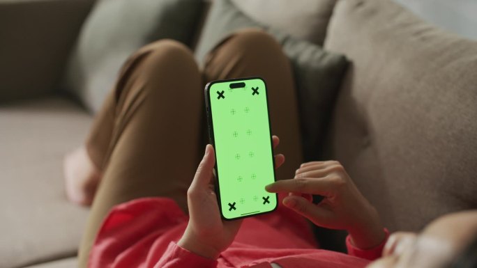 女子使用绿色屏幕的智能手机