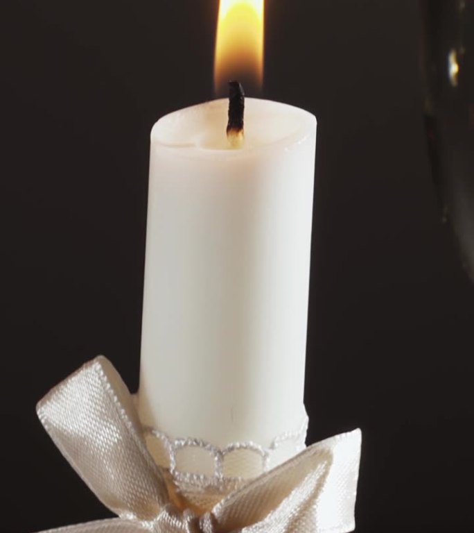 香槟和两支白色的结婚蜡烛还有婚戒，幻灯片，特写。垂直视频。
