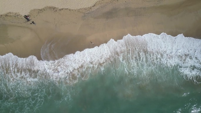 鸟瞰透明的蓝色大海，在夏天阳光明媚的日子里有美丽的海浪。热带景观从空气的海洋与蔚蓝的水，在日落沙底。