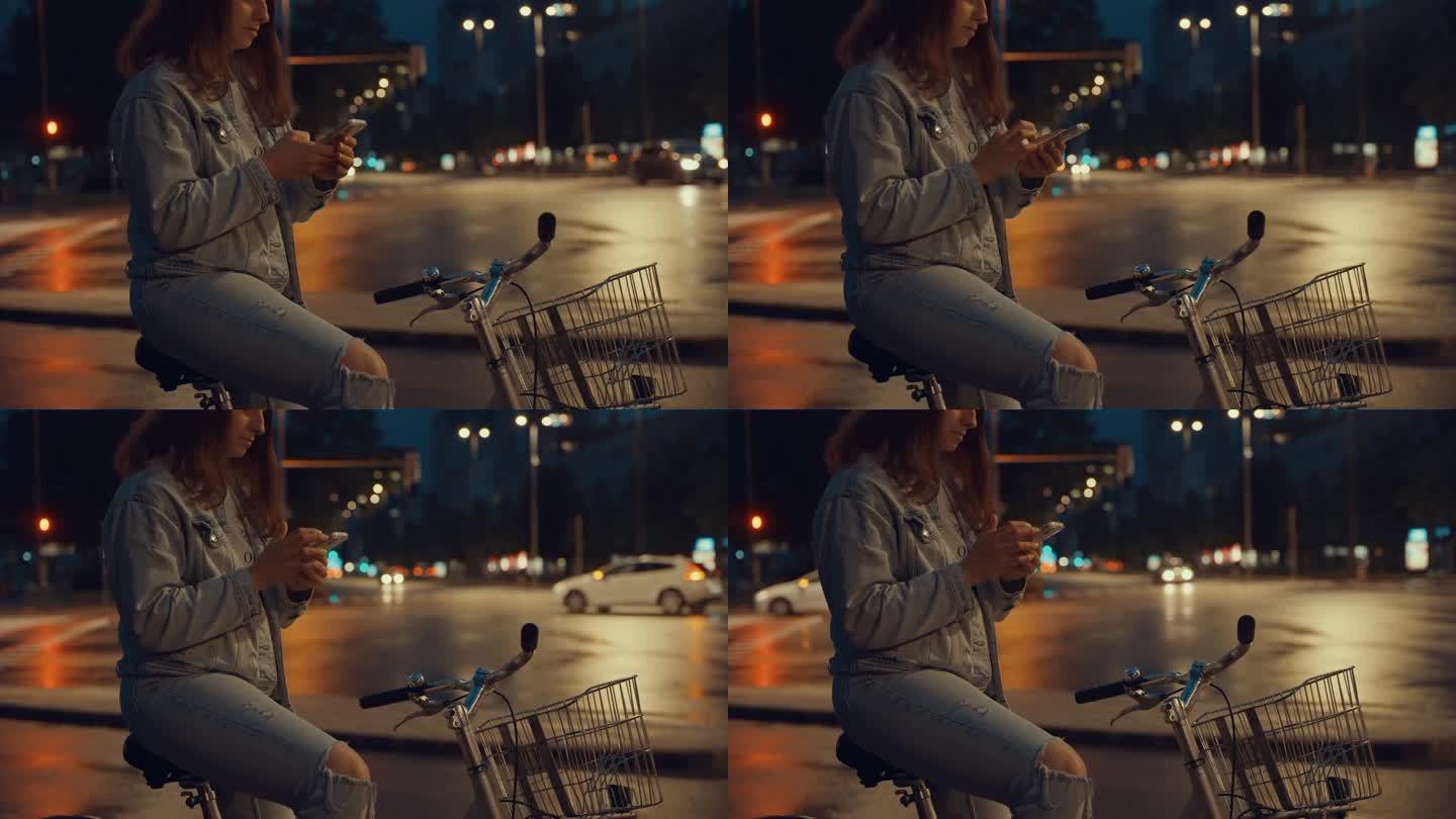 晚上在人行横道上骑自行车拿智能手机的年轻女子