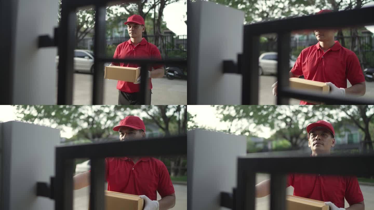 一名身穿红色制服的快递员拿着包裹箱，为收件人按铃。联系房子前面的听筒