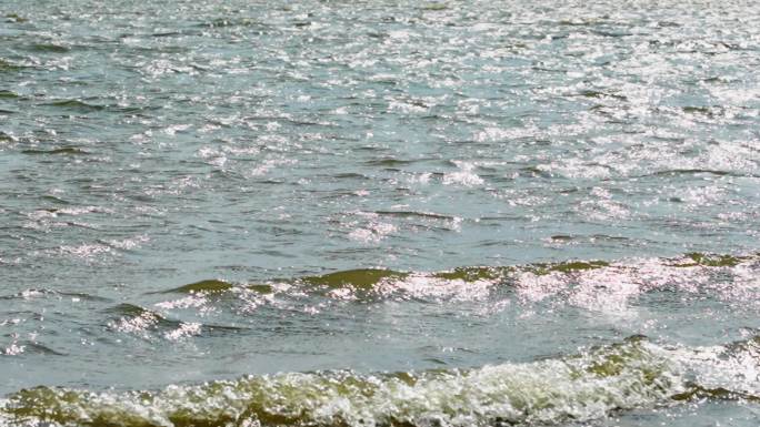 浪花拍打在岸边的沙滩岩石上