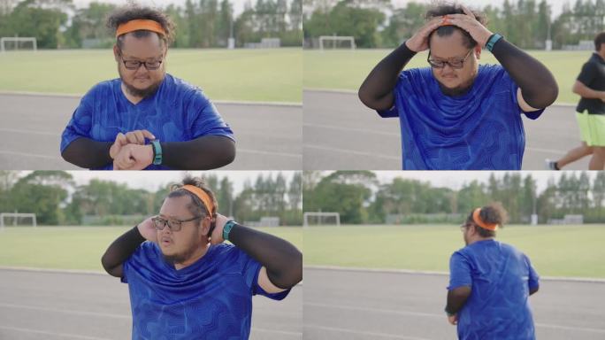 一名胖乎乎的亚洲男子，早上在体育馆的跑道上独自慢跑减肥前，用智能手表监测步数和卡路里消耗。