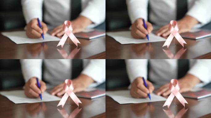 医生桌子上的粉红丝带乳腺癌意识标志