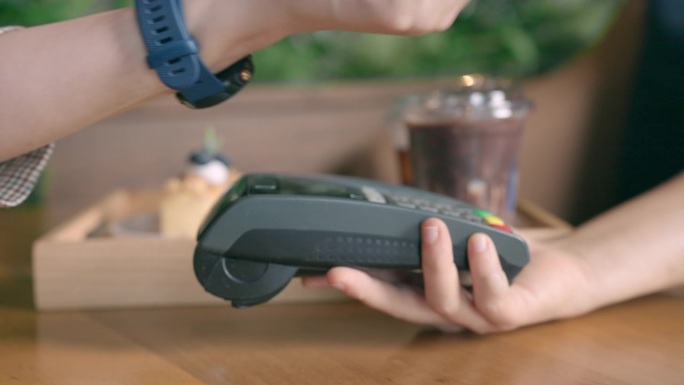 在咖啡馆里，买家和卖家通过电子设备接触，用可穿戴智能手环进行非接触式支付。购买非接触式智能手表。