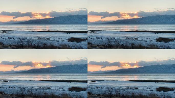 在寒冷的冬夜，太阳落在结冰的犹他湖的云层后面