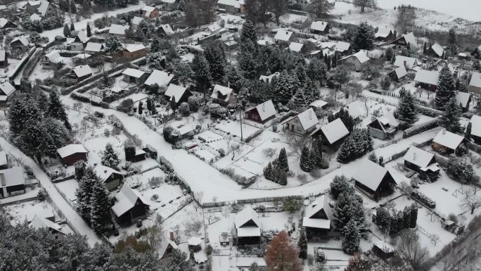 鸟瞰图宁静的小镇在深，新鲜的雪，初冬。大雪中的乡村屋顶。郊区住宅小区冬日。欧洲波兰。
