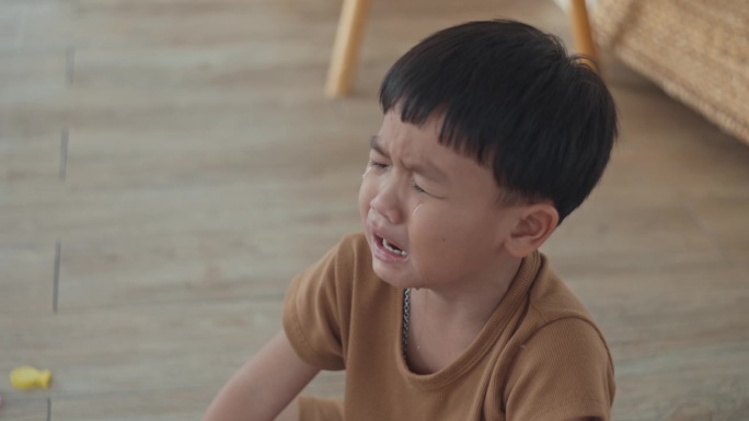 亚洲小男孩在家里的房间里哭