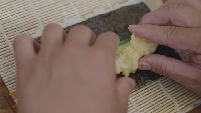 将海苔填满米饭卷成卷