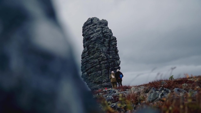 山的一部分很近。夹石表面有地衣。黑白相间的山。背景是草原