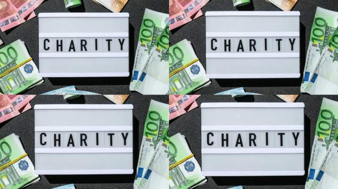 在欧洲钞票周围用黑色字母慈善的灯箱板。金钱、商业、金融、投资、储蓄