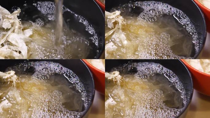 一段将鱼鱼汤倒入装有海带和海带的碗中的视频。从左到右。