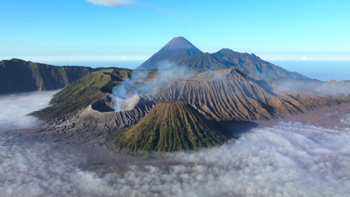 空中无人机超缩日出场景移动的云，雾和烟雾的喷发覆盖火山Mts. Bromo，塞默鲁，巴托克和威达顿，