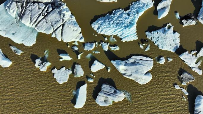冰山漂浮棕色冰川泻湖变暖气候蓝色冰抽象航空