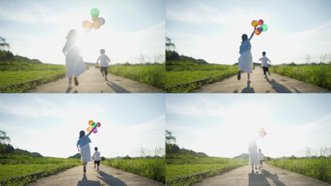 年轻妈妈陪伴孩子奔跑户外亲子彩色气球追逐