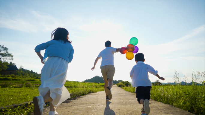 一家三口逆光奔跑追逐嬉戏彩色气球温馨家庭