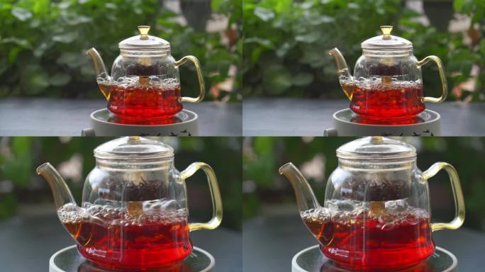 在漂亮的花园里用电炉玻璃茶壶煮红茶