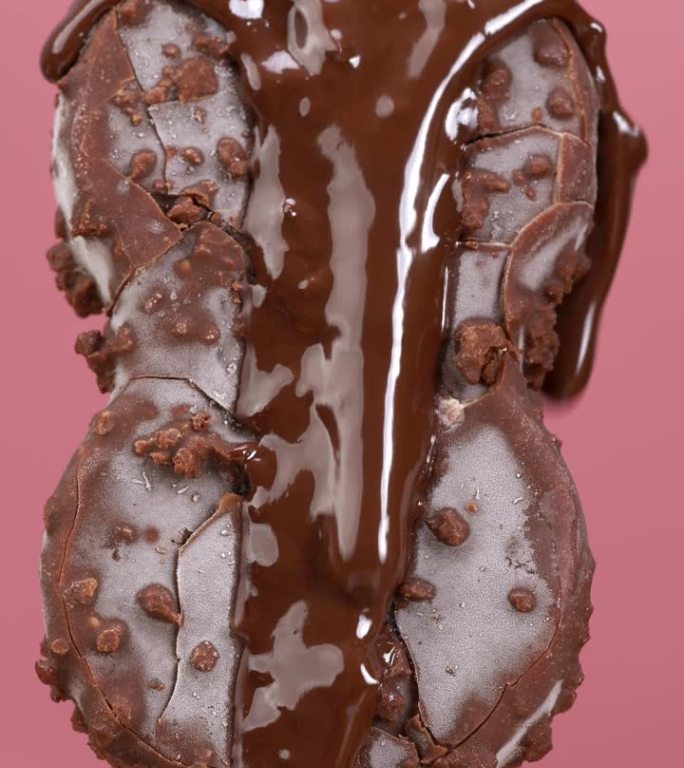 将融化的巧克力倒在粉色背景的雪糕上。
