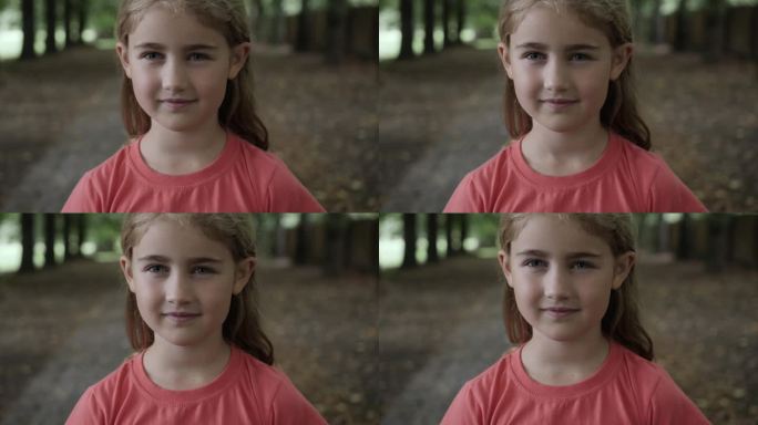 肖像微笑的小女孩看着相机。孩子在户外快乐地笑。好奇的小女孩肖像。面对有趣的沉思的孩子。笑得可爱漂亮的