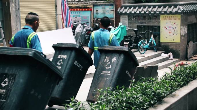 环卫工人清理垃圾拖垃圾桶街头